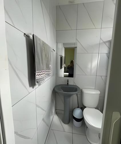 a white bathroom with a toilet and a sink at Residencial JC II sua casa em Belém do Pará in Belém