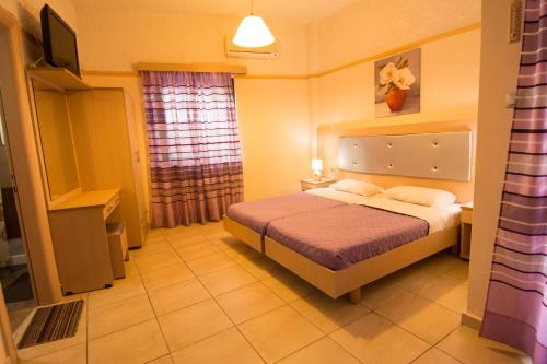 Ένα ή περισσότερα κρεβάτια σε δωμάτιο στο Ενοικιαζόμενα Δωμάτια Μίνος