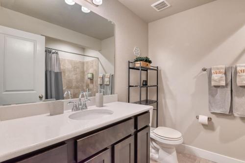 a white bathroom with a sink and a toilet at Family friendly 5bd3bath 3CarGarage GameRoom in Cimarron Hills