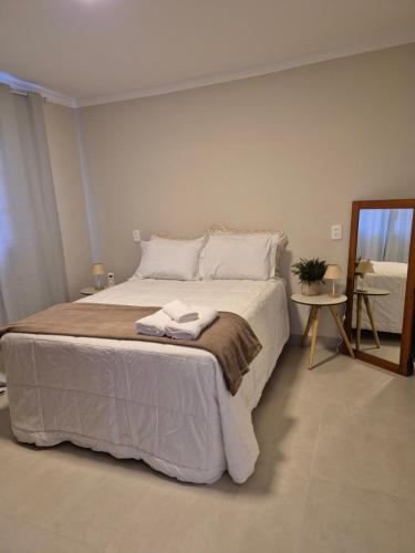a bedroom with a large bed with towels on it at Acolhedor ao lado de Vinícola e Centro in Espirito Santo Do Pinhal