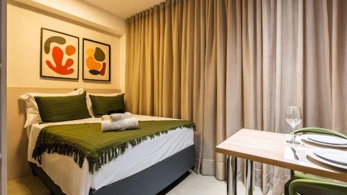 a hotel room with a bed and a table with glasses at By DH: Luxo e conforto em Perdizes, aos poucos minutos do Allianz parque in Sao Paulo