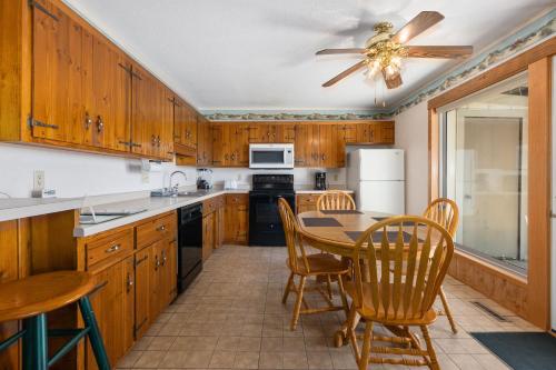 a kitchen with wooden cabinets and a table and chairs at The Lodges at Breezy Point in Breezy Point