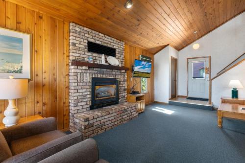 a living room with a stone fireplace in a house at The Lodges at Breezy Point in Breezy Point