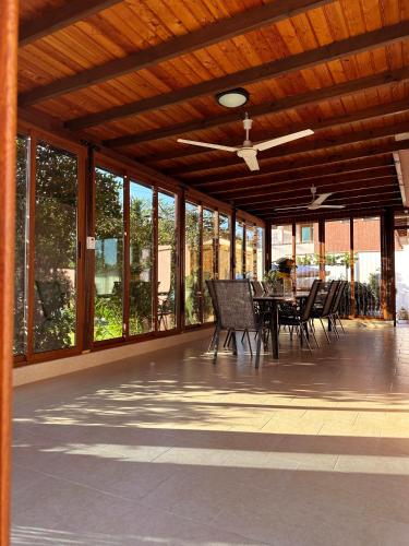a screened porch with chairs and a table with a ceiling fan at Guest House Doni in Sandanski