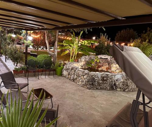a patio with a stone fountain in a yard at night at Guest House Doni in Sandanski