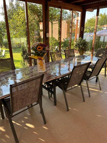 a glass table and chairs on a patio at Guest House Doni in Sandanski