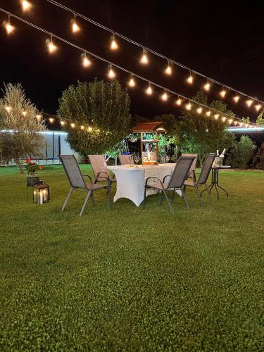 a table and chairs in a yard with lights at Guest House Doni in Sandanski