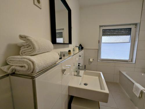 une salle de bain blanche avec un lavabo et un miroir dans l'établissement 55qm Messe Wohnung, Trade Fair, 6 Minuten zur Messe, à Rheinstetten