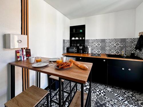 - une cuisine avec une table et une plaque de cuisson dans l'établissement Appartement entier neuf avec balcon privé - Centre Montpellier, à Montpellier
