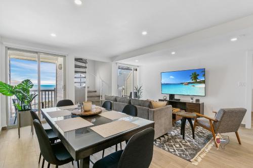 a living room with a dining table and a television at Bahia Mar Solare Beachfront Resort Condos with Two Pools in South Padre Island
