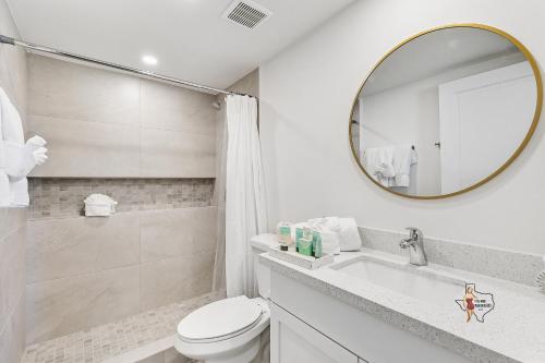 a white bathroom with a toilet and a mirror at Bahia Mar Solare Beachfront Resort Condos with Two Pools in South Padre Island