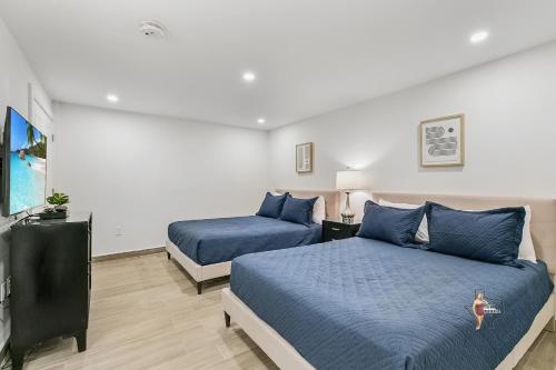 a bedroom with two beds and a tv in it at Bahia Mar Solare Beachfront Resort Condos with Two Pools in South Padre Island