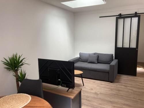 un salon avec un canapé et une télévision dans l'établissement Maison 2 pièces Ouistreham, à Ouistreham