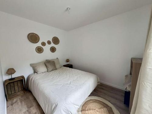 une chambre avec un lit blanc et un parquet dans l'établissement Maison 2 pièces Ouistreham, à Ouistreham