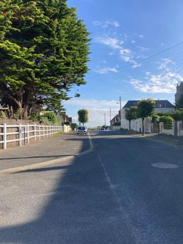 une rue vide avec une voiture en descendant la route dans l'établissement Maison 2 pièces Ouistreham, à Ouistreham