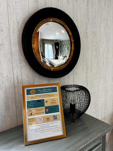 a mirror on a wall with a sign on a table at Les Vieilles Digues in Beauvoir