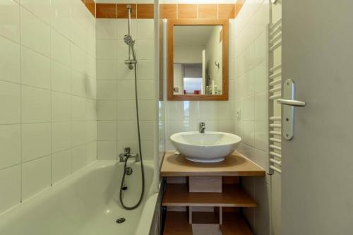 La salle de bains est pourvue d'un lavabo et d'une baignoire avec un miroir. dans l'établissement Résidence Sainbois - Résidence SAINBOIS N°223 MAE-1541, à La Plagne Tarentaise