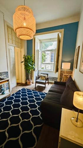 a living room with a black couch and a rug at Family downtown apartment - Se21 in Lisbon