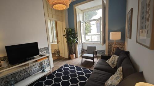 a living room with a couch and a tv at Family downtown apartment - Se21 in Lisbon