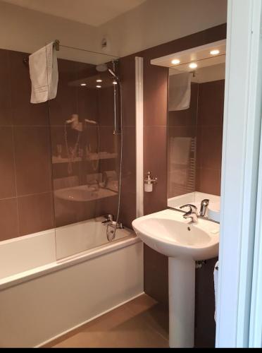 une salle de bain avec un lavabo, une douche et une baignoire dans l'établissement Hôtel Restaurant TOQUE et PASSION, à Morhange