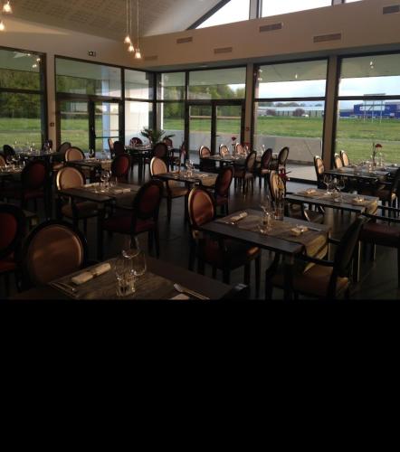 une salle à manger avec tables, chaises et fenêtres dans l'établissement Hôtel Restaurant TOQUE et PASSION, à Morhange