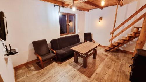 a living room with a table and a couch and chairs at Leśna Przystań in Busko-Zdrój