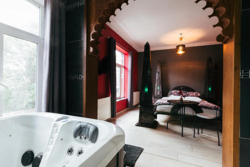 a bathroom with a tub and a bedroom with a bed at Hotel Riad Nour in Liège