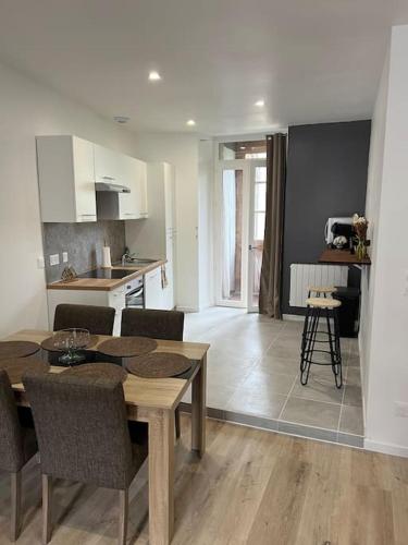 une cuisine et un salon avec une table et des chaises dans l'établissement Le Chaleureux Luchonnais, à Luchon