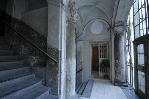Un pasillo vacío de un edificio con escaleras y ventanas. en Monteoliveto Bed & Breakfast, en Nápoles