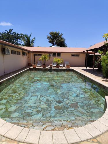 a swimming pool in a yard with a building at Les studios de l'embarcadere in Kourou