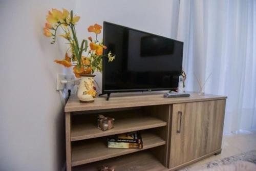 a flat screen tv sitting on a wooden entertainment center at Home sweet home in Loutraki