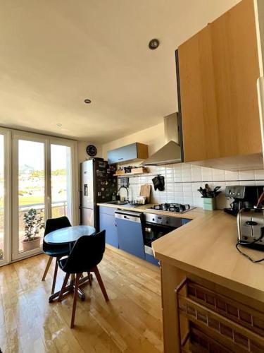 une cuisine avec une table et quelques chaises dans l'établissement Appartement calme avec vue panoramique, à Toulon