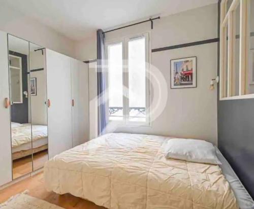 une chambre avec un grand lit et une fenêtre dans l'établissement Eiffel Tower Invalides Cosy Flat, à Paris