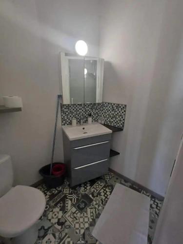 une salle de bain avec un lavabo, des toilettes et un miroir dans l'établissement Le Luminaire, à Niort