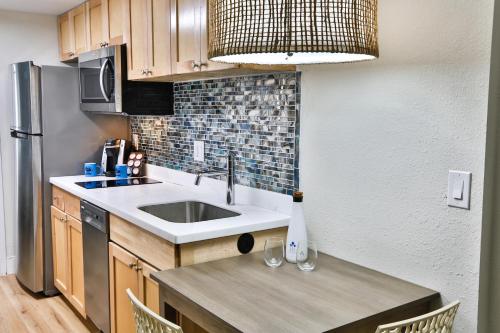 a small kitchen with a sink and a refrigerator at Princess Royale Oceanfront Resort in Ocean City