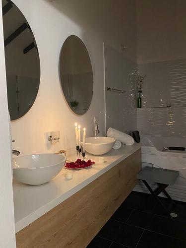 a bathroom with two sinks and two mirrors at Hotel Villa Teresita in Sáchica