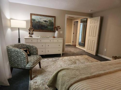 a bedroom with a bed and a chair and a dresser at NEW! Peaceful Retreat at Nary Hill in Wolfeboro