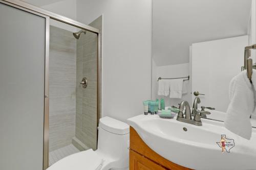 a white bathroom with a sink and a shower at Bahia Mar Solare Beachfront Resort Condos with Two Pools in South Padre Island
