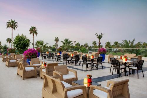 a patio with tables and chairs and palm trees at IC Hotels Santai Family Resort - Kids Concept in Belek
