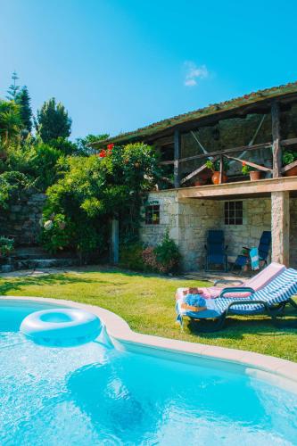 a swimming pool in front of a house at Just Like Home - Casa do Cadinho in Viana do Castelo