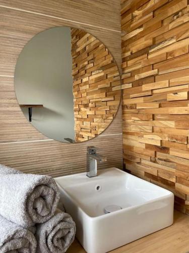 une salle de bain avec un lavabo blanc et un miroir dans l'établissement Petite maison au cœur de la ville, à Pouzauges