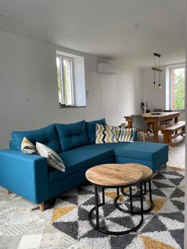 un salon avec un canapé bleu et une table dans l'établissement Petite maison au cœur de la ville, à Pouzauges