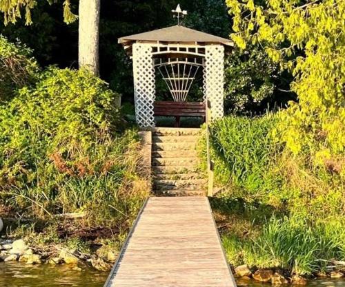 a wooden boardwalk leading to a gazebo with a bench at Latitude Adjustment in Traverse City