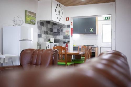 a kitchen and dining room with a table and chairs at Cantinho do Cruzeiro das Lajes in Praia da Vitória