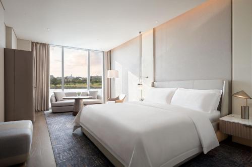 a hotel room with a large white bed and a couch at The St. Regis Belgrade in Belgrade