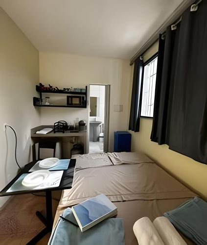 a bedroom with a bed and a desk and a table at Residencial JC II sua casa em Belém do Pará in Belém