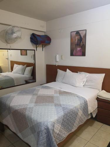 Una habitación de hotel con dos camas y un espejo. en Hs Baltimore, en Lima