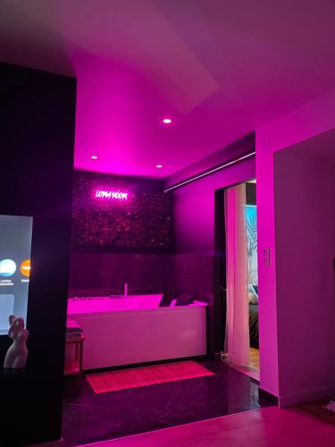 Camera viola con vasca e illuminazione rosa di Logement atypique-Loma room a Fougères