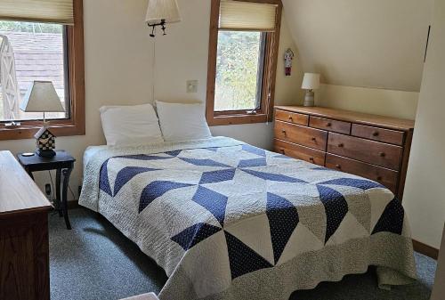 una camera con un letto con una trapunta blu e bianca di Northern Lights-Lake Michigan a Northport
