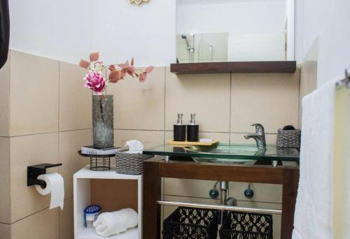 a bathroom with a sink and a vase with flowers at City Break - Luxury Golf Estate & Country Club in Johannesburg